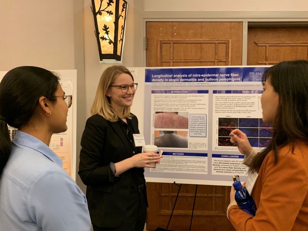 Researchers talking about a poster abstract