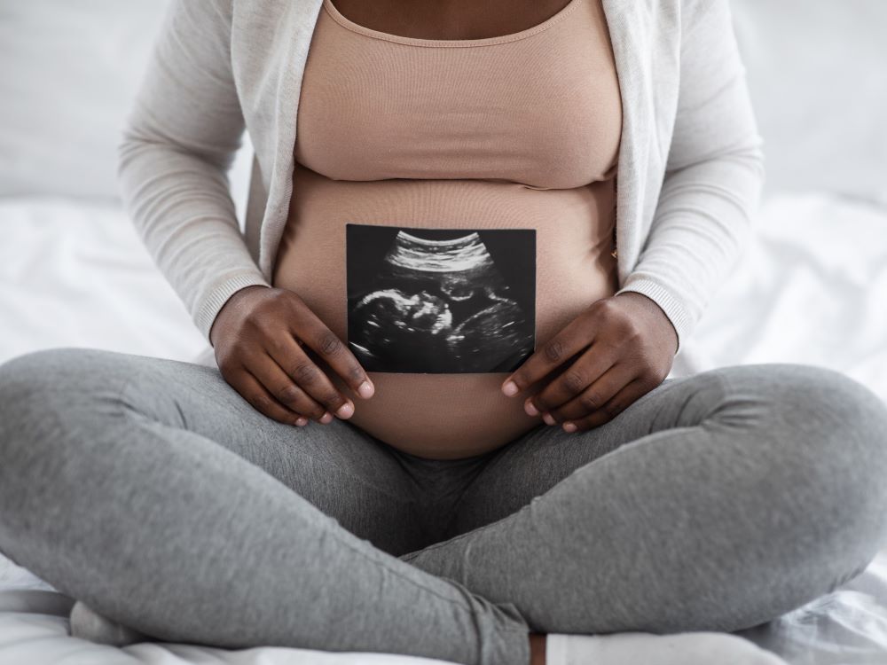 Pregnant woman holding ultrasound