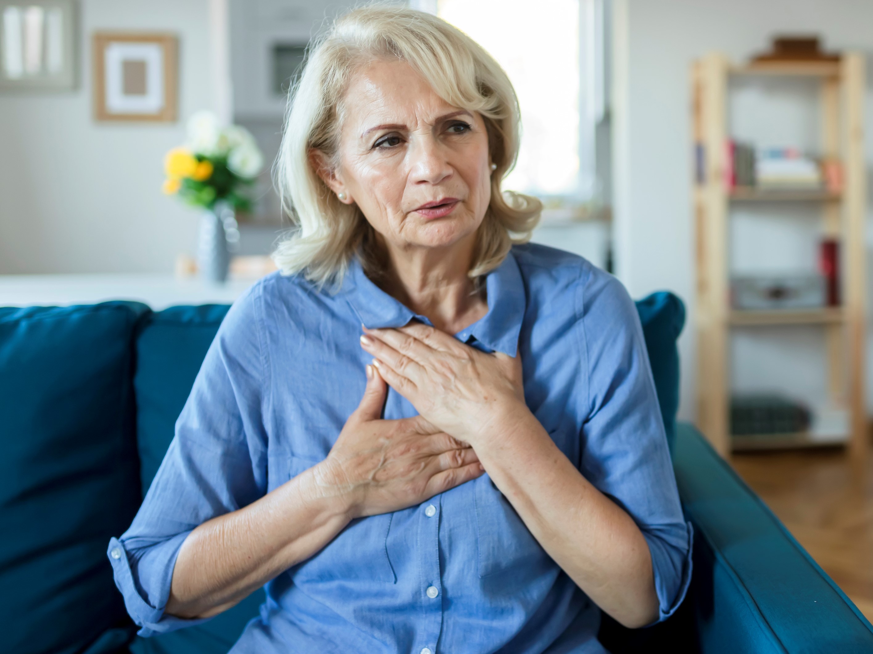 Woman looking stressed with hands on chest