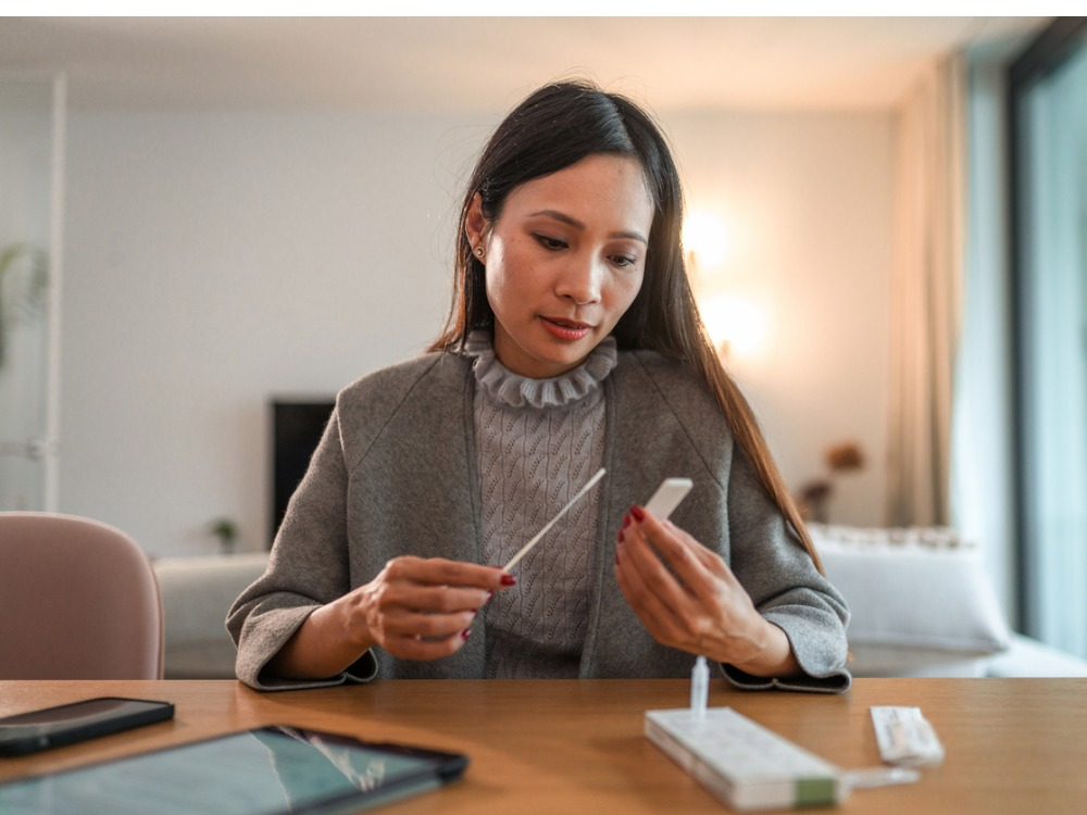 woman looking at COVID self-test kit